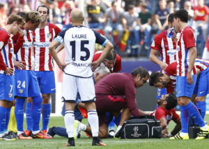 Augusto se duele en el suelo ante la mirada preocupada de sus compañeros. Foto: www.clubatleticodemadrid.com