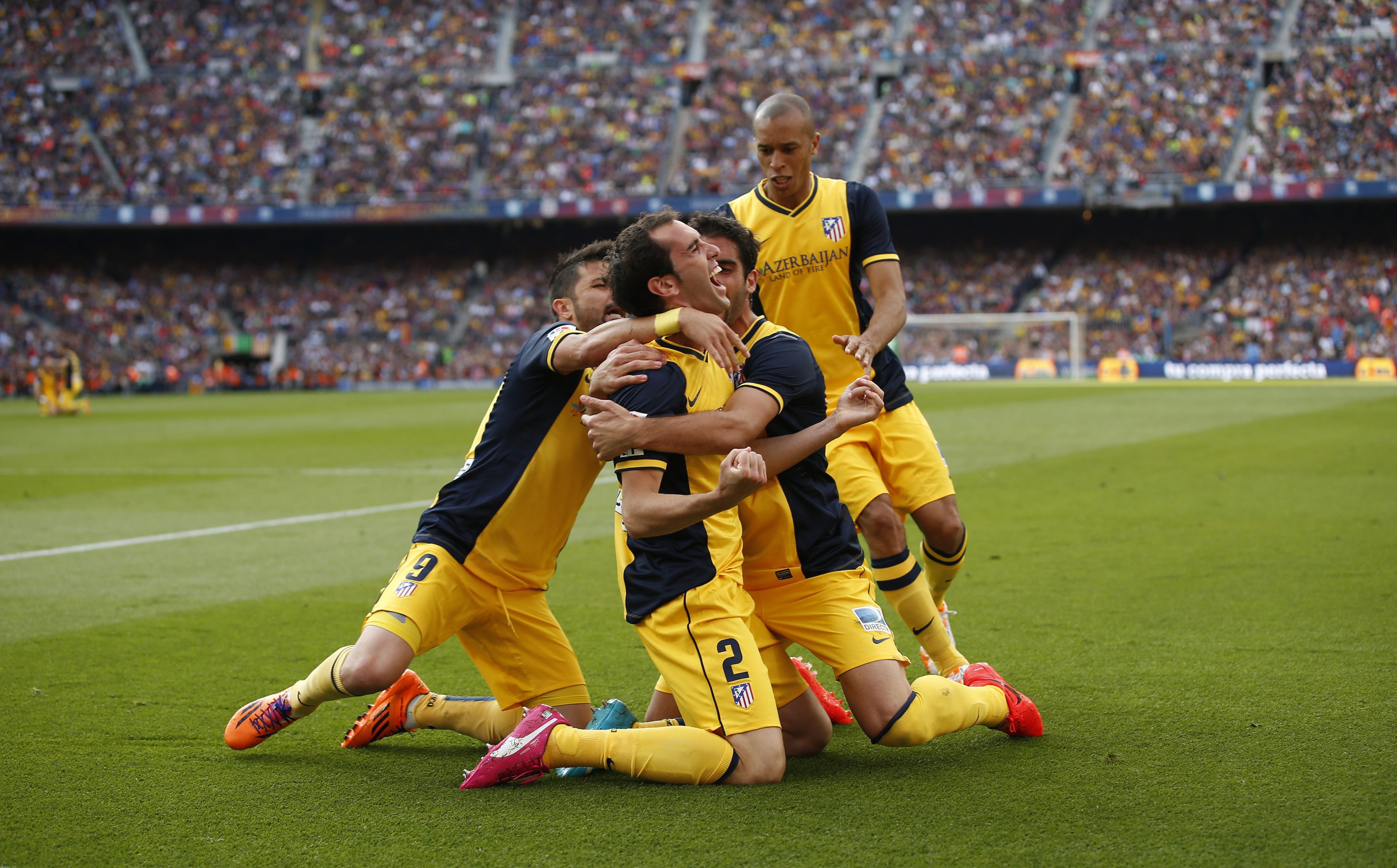 Atletico Madrid's Godin celebrates with teammates after scoring against Barcelona during their Spanish first division soccer match in Barcelona